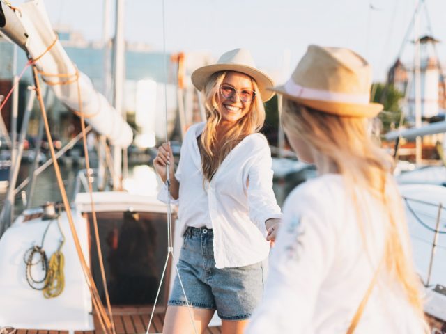 two-beautiful-blonde-girls-in-white-and-straw-hat-on-the-yacht-at-the-pier.jpg